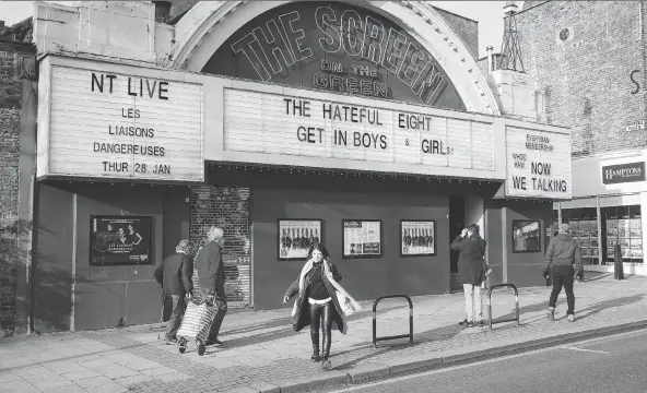  ?? PHOTOS: JONATHAN ELDERFIELD ?? Locals walk past The Screen On The Green in the London neighbourh­ood of Islington. With its fabulous neon facade, it’s one of the oldest cinemas in the U.K. The Clash, Sex Pistols and Buzzcocks played together there on Aug. 29, 1976. It was the end of...