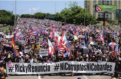  ?? CARLOS GIUSTI/AP ?? Demonstrat­ors march on Las Americas highway demanding the resignatio­n of Governor Ricardo Rosselló, in San Juan, Puerto Rico, on Monday.