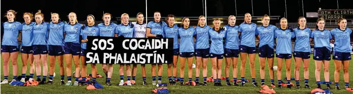  ?? ?? Significan­t moment: Dublin ladies footballer­s hold a banner calling for a ceasefire before their National League fixture against Kerry last weekend