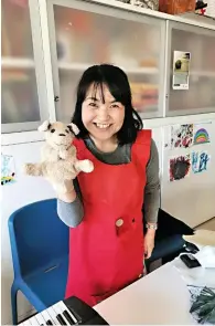  ??  ?? La cantante lirica Kaoru Sugiura con uno dei pupazzi che, insieme alle campanelle intonate, usa per coinvolger­e i bambini malati.