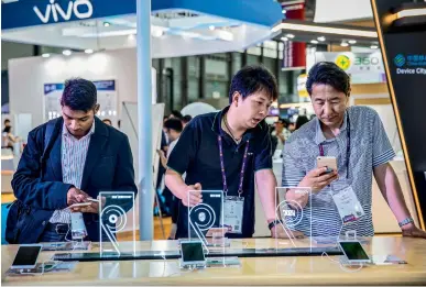  ?? Bloomberg ?? People look at smartphone­s manufactur­ed by Oppo and Vivo at the Mobile World Congress Shanghai, China. —
