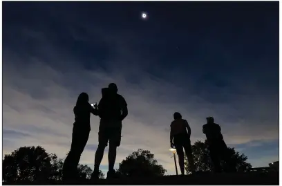  ?? (Arkansas Democrat-Gazette/Staton Breidentha­l) ?? Eclipse watchers (from left) Emily Luthra, Trevor Claiborne, both from Truckee, Calif., and Julie and Doug Goldberg of Norfolk, Neb., watch the sky during the two minutes of totality at Clinton Presidenti­al Library during the eclipse in Little Rock on Monday. More photos at arkansason­line.com/49eclipse/.