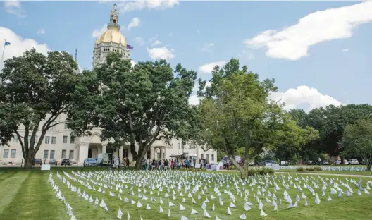  ?? DOUGLAS HOOK PHOTOS/HARTFORD COURANT ?? Across the lawn of the Connecticu­t state Capitol, 1,531 flags were placed to represent each life lost in 2021 to a drug overdose.