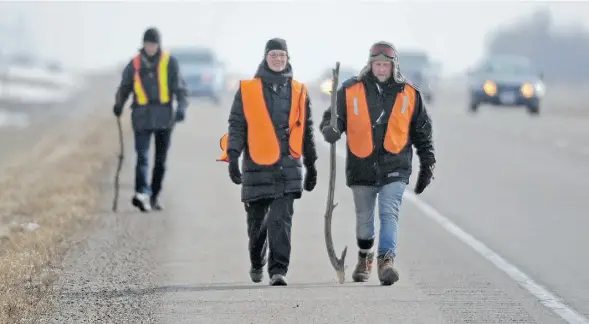  ?? John Lucas/Edmonton Journal ?? Laurens Thiessen Van Esch (left), Ann Heinrichs and Brad Langendoen trek Highway 16 on Tuesday en route to the Truth and Reconcilia­tion Commission.