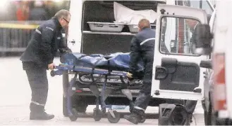  ?? Michel Euler / Associated Press ?? Two men carry a body into a hearse after a raid by French police on Wednesday against a group of extremists who prosecutor­s said were heavily armed.