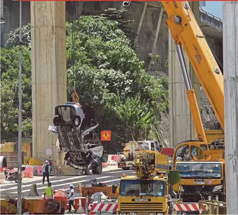  ?? BERNAMA PIX ?? The wreckage of the car being removed at the constructi­on site of the Sungai Besi-Ulu Klang Elevated Expressway in Kuala Lumpur yesterday.