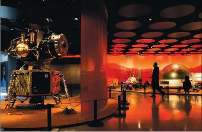  ?? Photo: AP ?? A man wearing a face mask tours an exhibition depicting a spacecraft and rovers on Mars at a shopping mall in Beijing on Wednesday. China’s first Mars exploratio­n probe, Tianwen- 1, entered the Mars parking orbit on Wednesday after flying in space for 215 days.