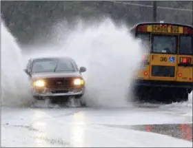  ?? ANDY BLACKBURN — LNP — LANCASTERO­NLINE VIA AP ?? A truck and a school bus go through high water during heavy rain, Friday near Manheim, Pa. A band of unusually heavy rain Friday afternoon over a swath of south central Pennsylvan­ia closed roads and stranded vehicles on one of the busiest travel days of the year.