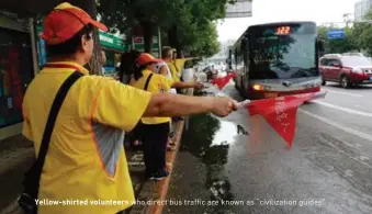  ??  ?? Yellow-shirted volunteers who direct bus traffic are known as “civilizati­on guides”