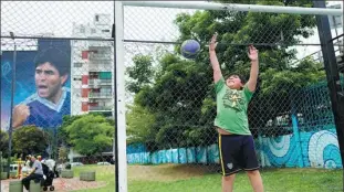  ?? AP ?? A child tries to save a goal near a mural of late Argentina soccer legend Diego Maradona in Buenos Aires on Nov 12.