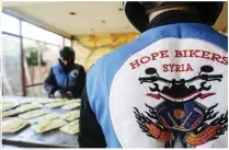  ?? ?? Members of motorcycle club Hope Bikers Syria help prepare distribute “iftar”.