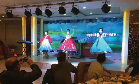  ?? (Sue-Lin Wong/Reuters) ?? NORTH KOREANS perform at the Pyongyang Restaurant in Shenyang’s Xita district in October. The area is known as ‘Korea Town,’ dotted with North Korean restaurant­s, hotels, shops and art galleries.