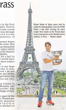  ??  ?? Rafael Nadal of Spain poses with his trophy for photograph­ers near the Eiffel Tower, a day after winning his men’s singles final match at the French Open tennis tournament at the Roland Garros stadium, in Paris. — Reuters photo