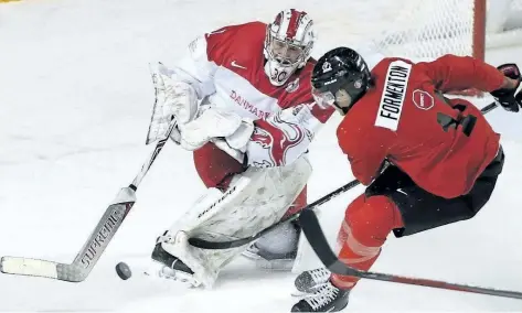  ?? PETER POWER/THE CANADIAN PRESS ?? Team Denmark goaltender Emil Gransoe shoots the puck away from Team Canada’s Alex Formenton during a world junior exhibition game in St Catharines, Ont., on Friday.