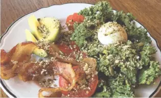  ?? PHOTO BY SARA JACKSON ?? The Paleo Breakfast is a large serving of kale tossed with a tangy Dijon vinaigrett­e, with a soft- or hard-boiled egg, tomato, half an avocado and a couple of slices of thick-cut bacon on the side. It’s sprinkled with pumpkin seeds and dukkah, an...