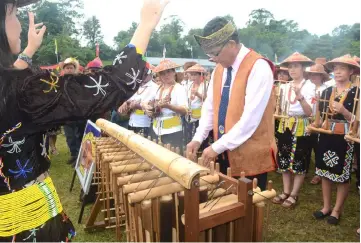  ??  ?? A conductor guides members of a Lun Bawang ‘bamboo band’ – a musical performanc­e that represents one of many cultural signatures of this community.