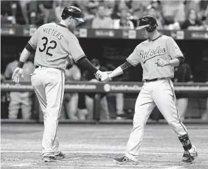  ?? REINHOLD MATAY/ASSOCIATED PRESS ?? Matt Wieters greets J.J. Hardy after Hardy’s two-run homer in the second inning gave the Orioles a 2-0 lead over the Rays at Tropicana Field. Hardy extended his hitting streak to nine games, and Wieters cut down Steven Souza Jr., who tried to steal...