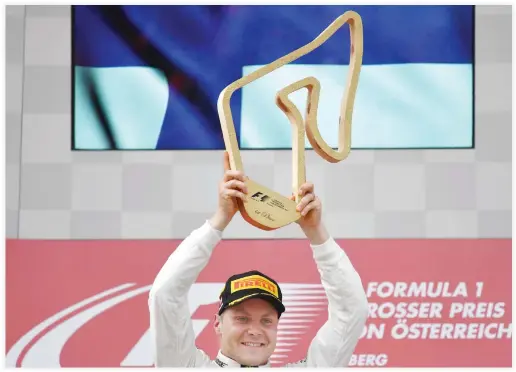  ??  ?? Mercedes’ Finnish driver Valtteri Bottas celebrates on the podium after winning the Formula One Austria Grand Prix at the Red Bull Ring in Spielberg on Sunday. (AFP)
