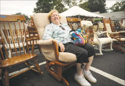  ?? Brian A. Pounds / Hearst Connecticu­t Media ?? Geri Amoroso, of Bridgeport, kicks back in the glider rocker she purchased as she waits for it to be carried to her car at the Operation Hope Tag Sale at First Church Congregati­onal in Fairfield on Sunday.