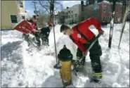  ?? ROBERT F. BUKATY — THE ASSOCIATED PRESS ?? Portland, Maine, firefighte­rs Andrew Johnston, left, Lt. Don Brown, center, and David Young dig out one of the city’s 1,500 fire hydrants, Wednesday, March 15, in Portland, Maine. A powerful nor’easter buffeted much of the Northeast with blizzard...