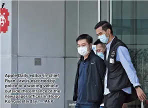  ??  ?? Apple Daily editor-in-chief Ryan Law is escorted by police to a waiting vehicle outside the entrance of the newspaper offices in Hong Kong yesterday. — AFP