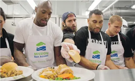  ?? VINCENZO D’ALTO/MONTREAL GAZETTE ?? Alouettes players, from left, Kyries Hebert, Nicolas Boulay, Chip Cox and Samuel Giguère serve a traditiona­l turkey dinner at the Welcome Hall Mission on Monday.