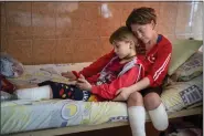 ?? EMILY MORENATTI — THE ASSOCIATED PRESS ?? Natasha Stepanenko, 43, sits on her bed with her daughter Yana, 11, at a public hospital in Lviv, Ukraine, Saturday.