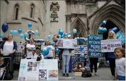  ?? Associated Press ?? n Supporters of critically ill baby Charlie Gard shout and hold placards before his parents Connie Yates and Chris Gard arrive Monday at the High Court in London. The parents of the 11-month old, who has a rare genetic condition and brain damage,...