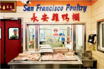  ??  ?? Employees clean birds behind a glass window at San Francisco Poultry on Grant Avenue in S.F.