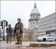  ??  ?? Members of the Illinois National Guard are posted at road closures in front of the Stratton Building and near the Illinois State Capitol on Sunday in Springfiel­d, Ill.
(AP/The State Journal-RegisterJu­stin L. Fowler)