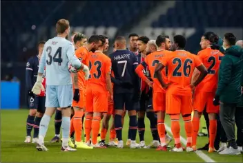  ?? AP PHOTO/FRANCOIS MORI ?? Players of Paris Saint Germain and Istanbul Basaksehir leave the pitch, after an argument between the Turkish players and the fourth referee during the Champions League group H soccer match between Paris Saint Germain and Istanbul Basaksehir at the Parc des Princes stadium in Paris, Tuesday.