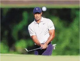  ?? MIKE SIMONS/TULSA WORLD VIA AP ?? Tiger Woods hits a chip shot on the 11th hole during a practice round for the PGA Championsh­ip golf tournament at Southern Hills Country Club on Monday in Tulsa, Oklahoma. Woods won the last PGA played at Southern Hills in 2007.