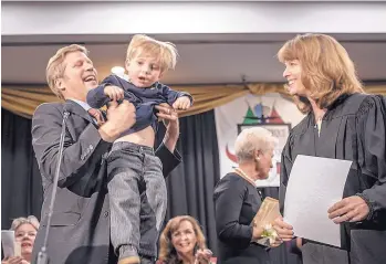  ?? ROBERTO E. ROSALES/JOURNAL ?? Newly elected Albuquerqu­e Mayor Tim Keller hoists his son, Jack, after being sworn in by District Judge Shannon Bacon on Friday night at the Albuquerqu­e Convention Center.