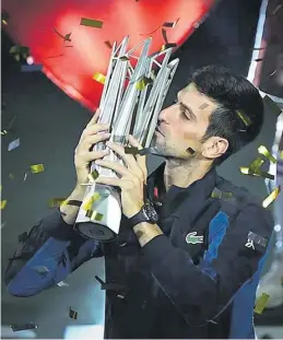  ?? AGENCIAS ?? ▶▶ Djokovic besa el trofeo que le acredita como ganador en Shanghái.