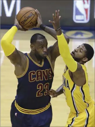  ?? DARRON CUMMINGS — THE ASSOCIATED PRESS ?? The Cavaliers’ LeBron James keeps the ball from the Pacers’ Paul George during the first half.