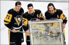  ?? AFP ?? Sidney Crosby (center) of the Pittsburgh Penguins poses with teammates Mike Matheson (right) and Evgeni Malkin to honor Crosby for his 1,000th NHL appearance prior to their home game against the New York Islanders on Saturday. Crosby is expected to star for Team Canada at the Beijing 2022 Winter Olympics.