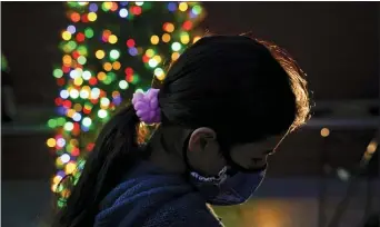  ?? JAE C. HONG — THE ASSOCIATED PRESS ?? A girl chooses a toy at a holiday toy giveaway held at Los Angeles Boys & Girls Club on Thursday in Los Angeles. According to a survey, some Americans are feeling a bit sadder, lonelier and less grateful than last year.