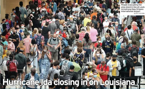  ?? SCOTT OLSON ?? People evacuating the area stand in line at Louis Armstrong New Orleans Internatio­nal Airport