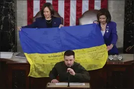  ?? JACQUELYN MARTIN — THE ASSOCIATED PRESS FILE ?? Vice President Kamala Harris and then-House Speaker Nancy Pelosi, right, react as Ukrainian President Volodymyr Zelenskyy presents lawmakers with a Ukrainian flag autographe­d by front-line Ukrainian troops as he addresses a joint meeting of Congress on Capitol Hill in Washington on Dec. 21.