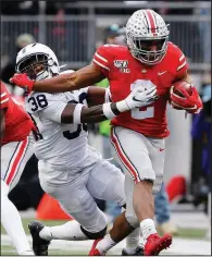  ?? AP/JAY LAPRETE ?? Ohio State running back J.K. Dobbins (right) stiff-arms Penn State defensive back Lamont Wade during the first half Saturday in Columbus, Ohio. Ohio State beat Penn State 28-17, as Dobbins rushed for 157 yards and two touchdowns.