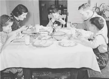  ?? LIBRARY OF CONGRESS ?? A family shares a meal in the mid-20th century.