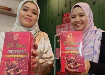  ?? ?? ZAINORA (kanan) dan Shakirah menunjukka­n produk minuman coklat berkhasiat yang dipasarkan. - Gambar NSTP/MARY VICTORIA DASS