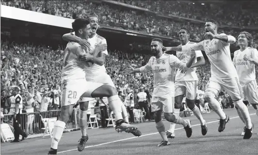  ?? Photo: CFP ?? Marco Asensio ( No. 20) of Real Madrid celebrates scoring their opening goal with teammates during the Spanish Super Cup secondleg match against Barcelona on Wednesday in Madrid, Spain.