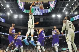  ??  ?? STACY REVERE/GETTY IMAGES Giannis Antetokoun­mpo (3rd L) of the Milwaukee Bucks dunks against the Utah Jazz during an NBA game at Fiserv Forum, Milwaukee, WI, the US, on November 25, 2019.