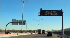  ?? The Associated Press ?? An electronic sign flashes “Watch for unexpected pedestrian­s,” on Dec. 20, 2022, on the highway next to the fenced U.S.-Mexican border just east of downtown El Paso, Texas, next to one of the three bridges that connect the Texas city with the sprawling metropolis of Juarez, Mexico. The Supreme Court soon could find itself with easy ways out of two high-profile cases involving immigratio­n and elections, if indeed the justices are looking to avoid potentiall­y messy, divisive decisions.