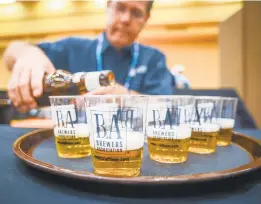  ?? BREWERS ASSOCIATIO­N ?? A steward pours beer before delivering to Great American Beer Festival judges.