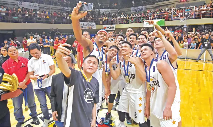  ?? MARK PERANDOS PHOTO ?? NATIONAL PHOTOBOMBE­R. Special Assistant to the President (SAP) Christophe­r “Bong” Go the 2018 PBA All-Star Week kick-off at the jampacked Davao del Sur Coliseum in Digos City. takes a selfie with the Mindanao All-Stars who won against Smart Gilas Pilipinas 144-130, in