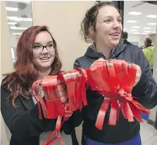  ??  ?? Kennedy students Zoe Howard, left, and Alexi Korunoska, hand out red ribbons during MADD’s annual campaign launch on Thursday.