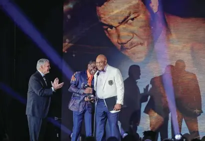  ?? Steve Gonzales / Staff photograph­er ?? Bill Worrell, from left, and Calvin Murphy share a moment with Hall of Fame inductee George Foreman on Wednesday.