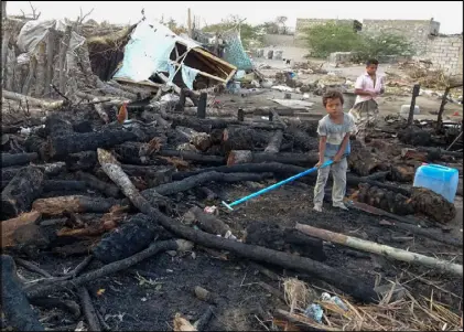  ??  ?? طفلان يمنيان نازحان مع عائلتيهما يقيمان في مخيم قضت عليه النيران في محافظة الحديدة